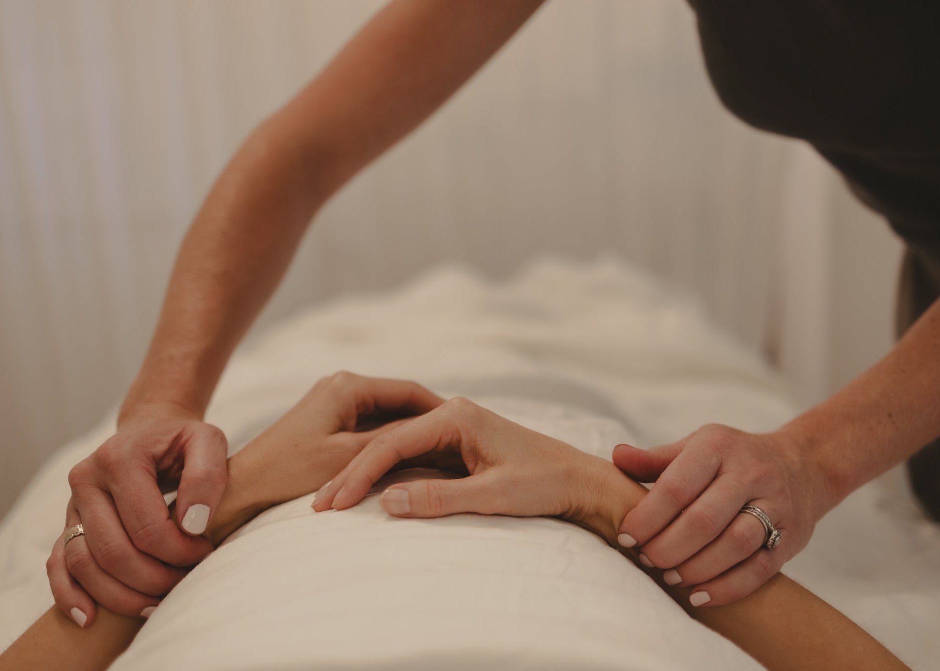 Person receiving Jin Shin Jyutsu with hands on a neutral background